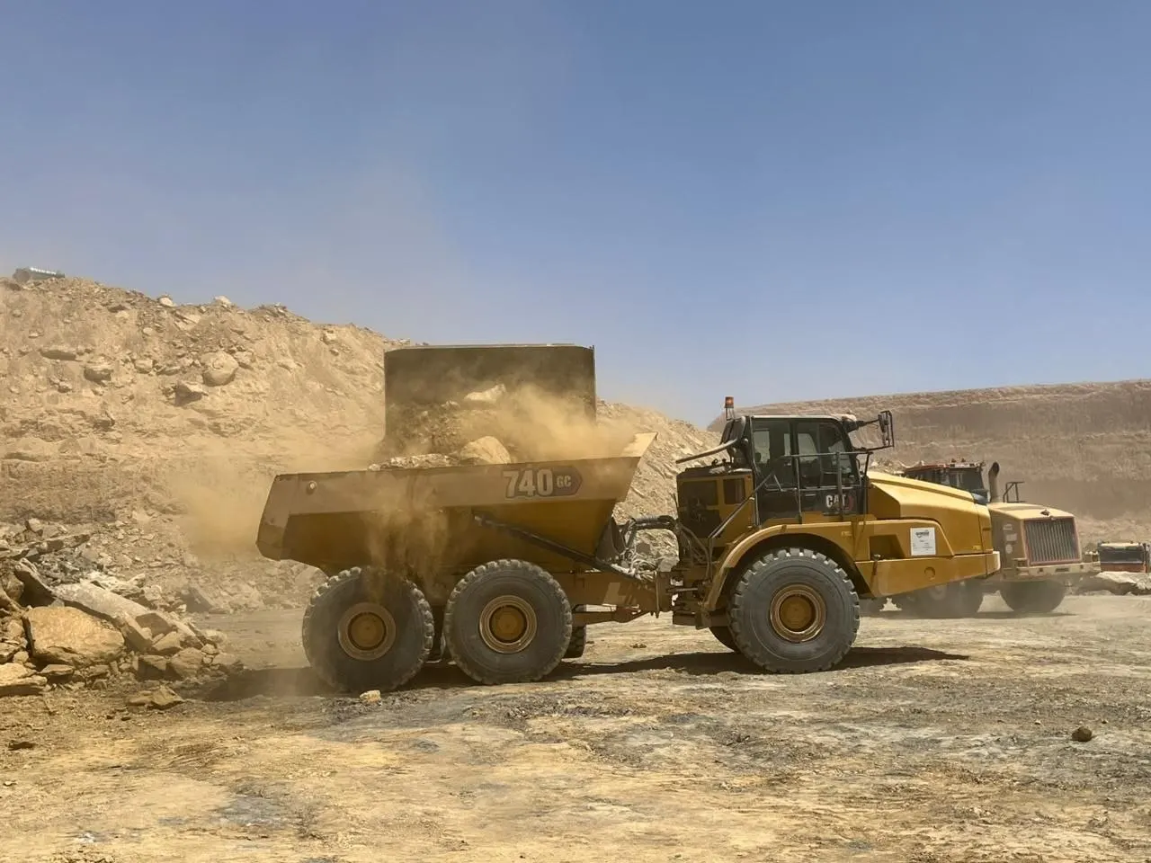Articulated dump truck being loaded with rock in the open pit